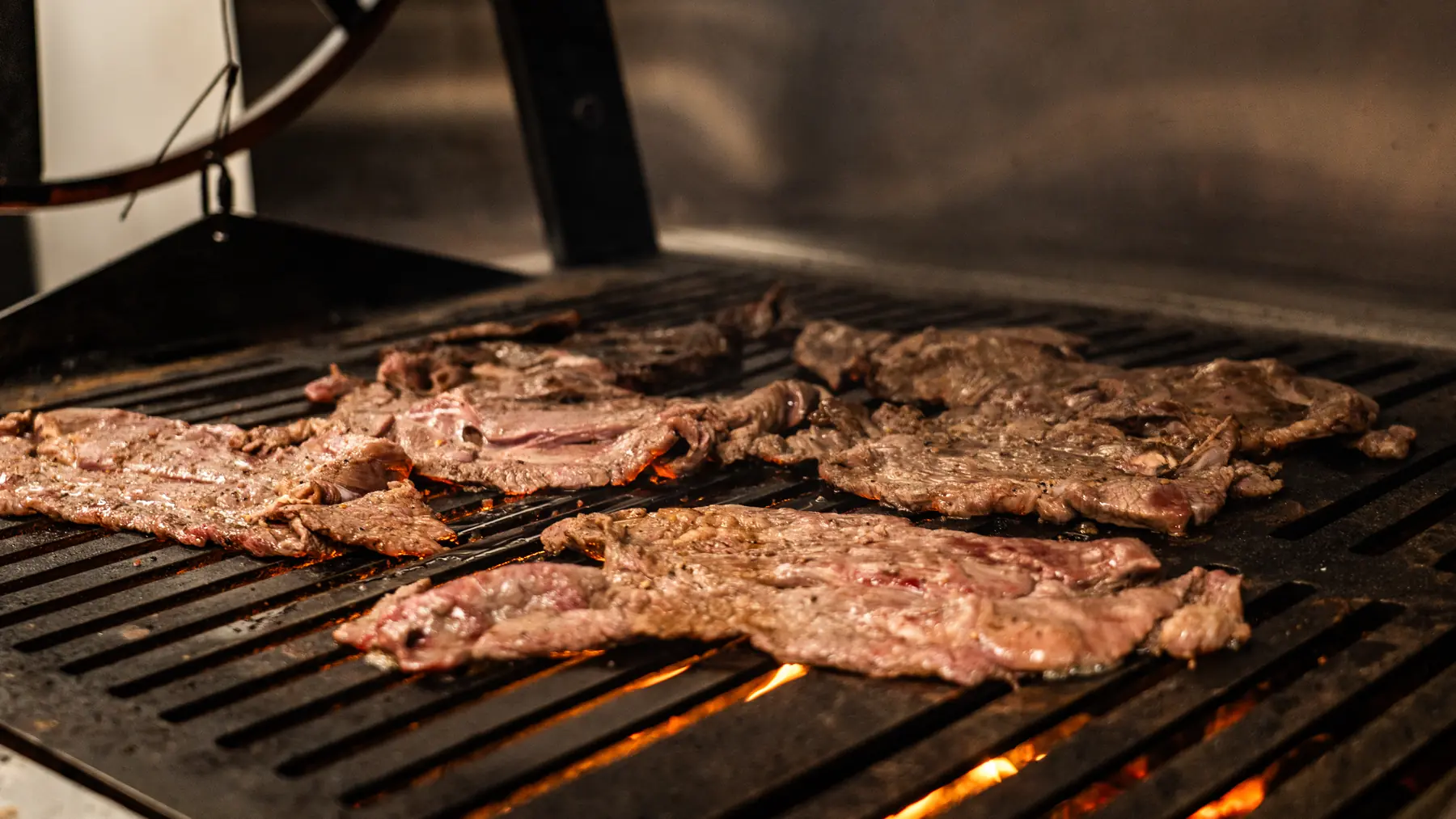 Carne asada cooking over the charcoal grill