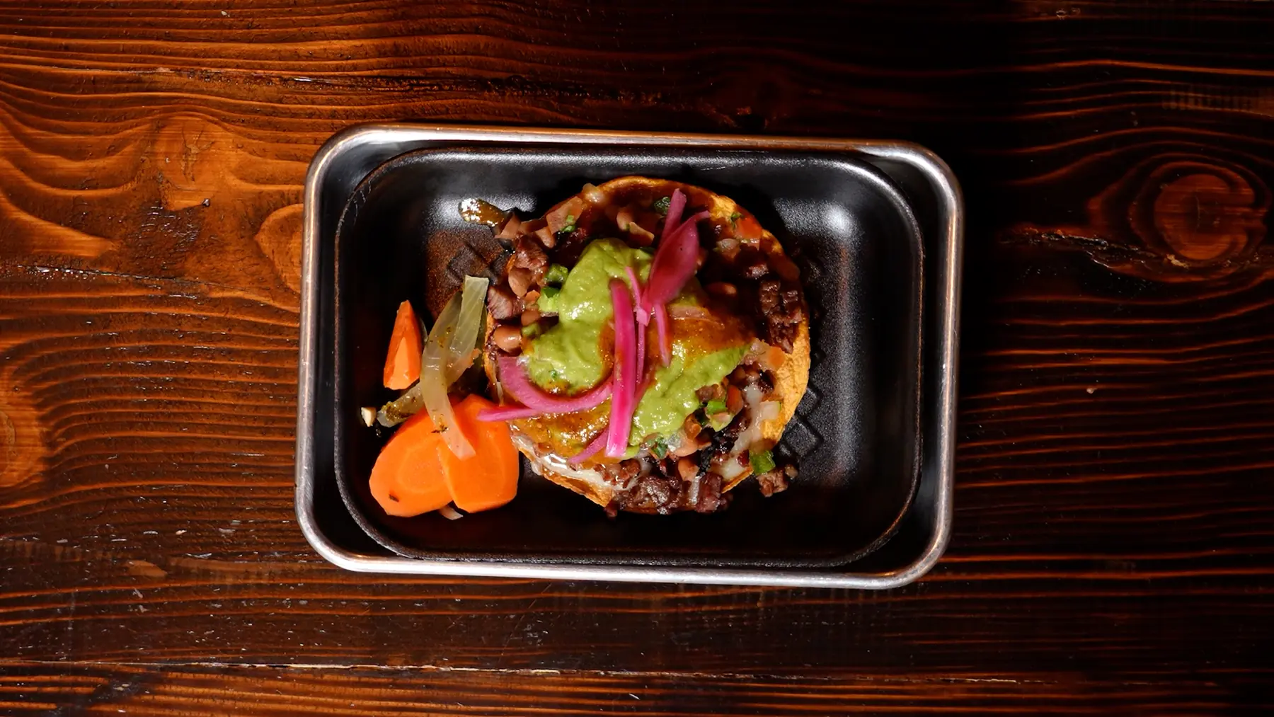 Street taco topped with pickled onions and salsa