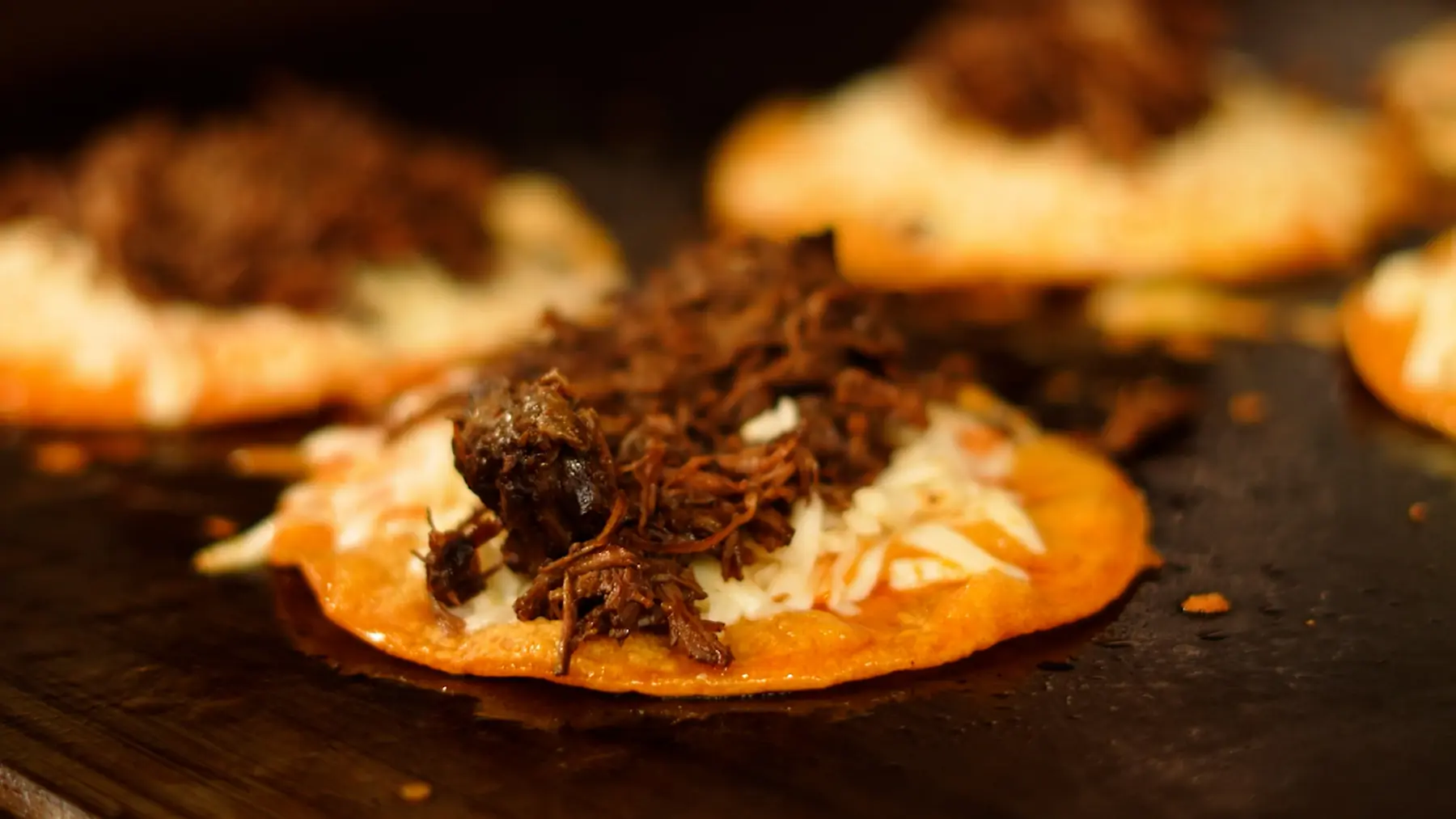 Birria tacos crisping on the griddle
